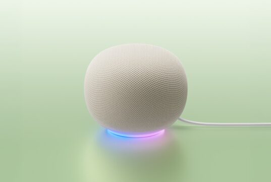 White Google Home Speaker on a mint backdrop with a blue-to-purple light ring and power cable