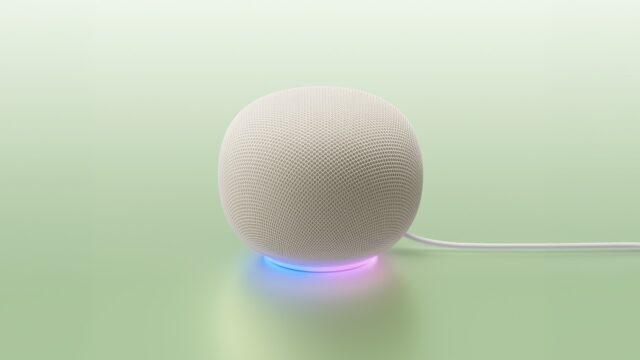 google-home-mcp-speaker-porcelain White Google Home Speaker on a mint backdrop with a blue-to-purple light ring and power cable
