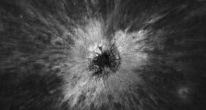 Overhead black-and-white Lunar Reconnaissance Orbiter view of McGetchin crater, a dark pit surrounded by a bright starburst of ejected debris