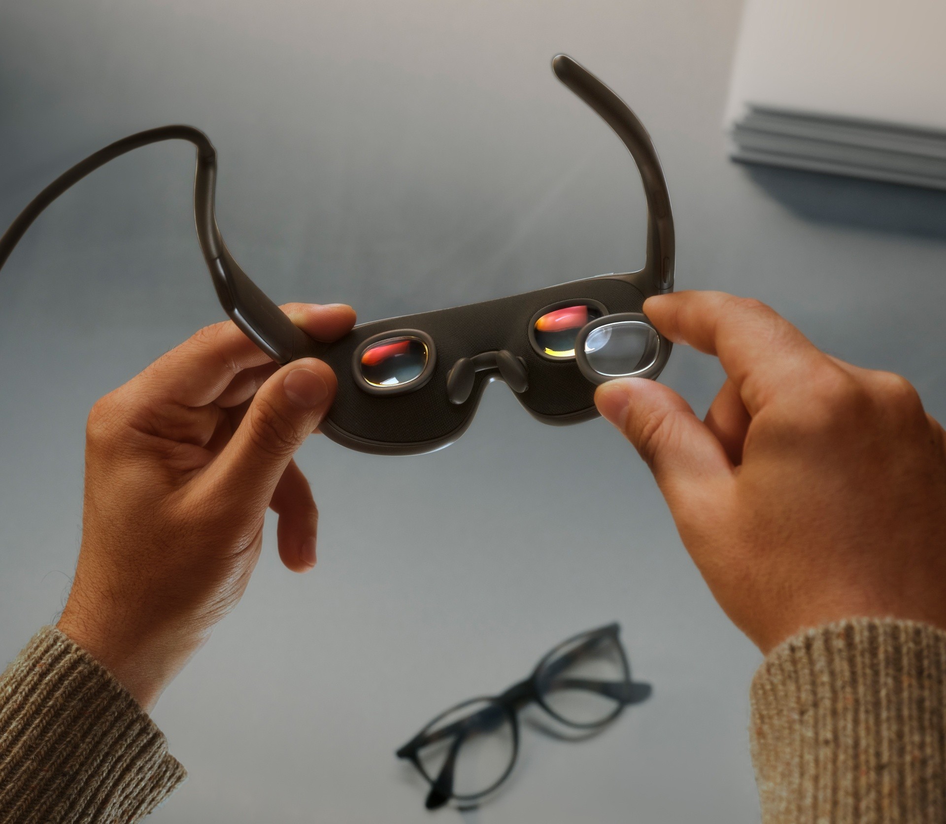 Hands holding Meta VR Glasses to show the compact pancake lenses inside the frames