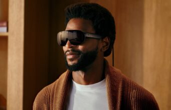 A man wearing Meta VR Glasses, which look like oversized black sunglasses