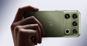 Motorola Signature 27 in PANTONE Capulet Olive held in hand, showing its quad camera housing with B&O branding