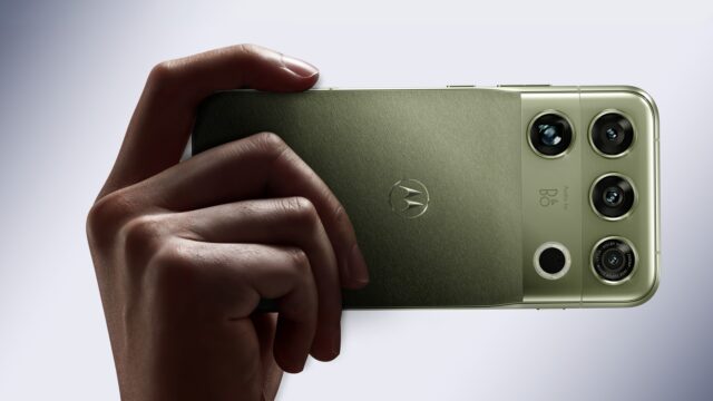 motorola-signature-27-capulet-olive Motorola Signature 27 in PANTONE Capulet Olive held in hand, showing its quad camera housing with B&O branding