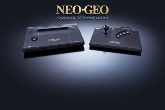 NEOGEO AES+ console and arcade stick in black under the gold Neo Geo logo