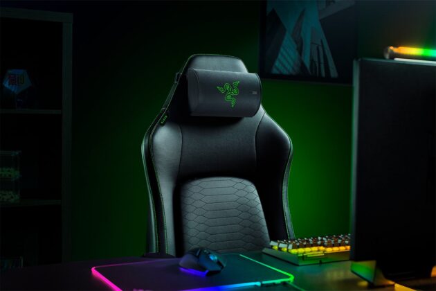 Razer gaming chair with the Clio X cushion in a green-lit room