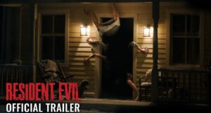 A figure contorted upside down in the doorway of a lit farmhouse porch at night, from Sony's Resident Evil official trailer