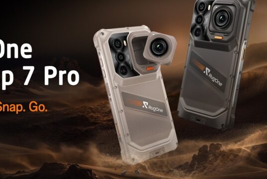 Sand and dark gray RugOne Xsnap 7 Pro phones with a detached cube action camera over desert dunes