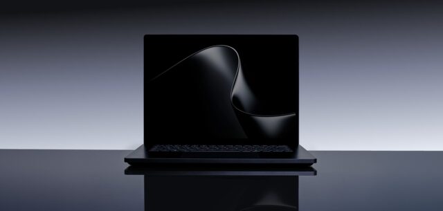 slu-hero Microsoft Surface Laptop Ultra open on a dark studio table, keyboard and 15-inch display visible