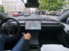 Tesla cabin with a visualization map on the center screen while the car drives through a European city street