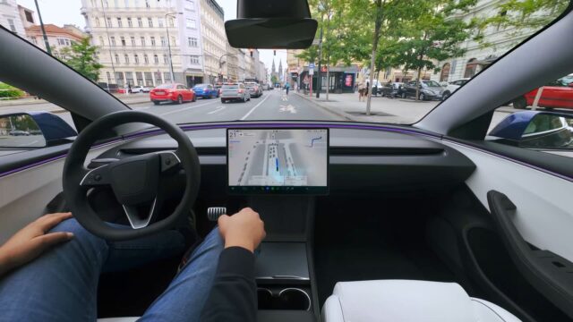 tesla-fsd-supervised-czechia-cabin Tesla cabin with a visualization map on the center screen while the car drives through a European city street