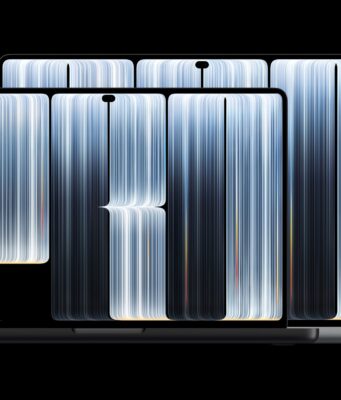 Two space-black MacBook Pro laptops with PROLED XDR Display, screens open, shown front-on against a black background