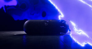 Beats Pokémon Pill Teaser Leaves Price and Date Unconfirmed AI-relit illustration of the Beats Pokémon Pill teaser, showing the speaker and strap against blue electrical effects