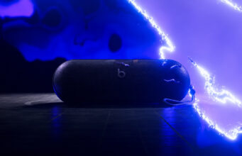 Beats Pokémon Pill Teaser Leaves Price and Date Unconfirmed AI-relit illustration of the Beats Pokémon Pill teaser, showing the speaker and strap against blue electrical effects
