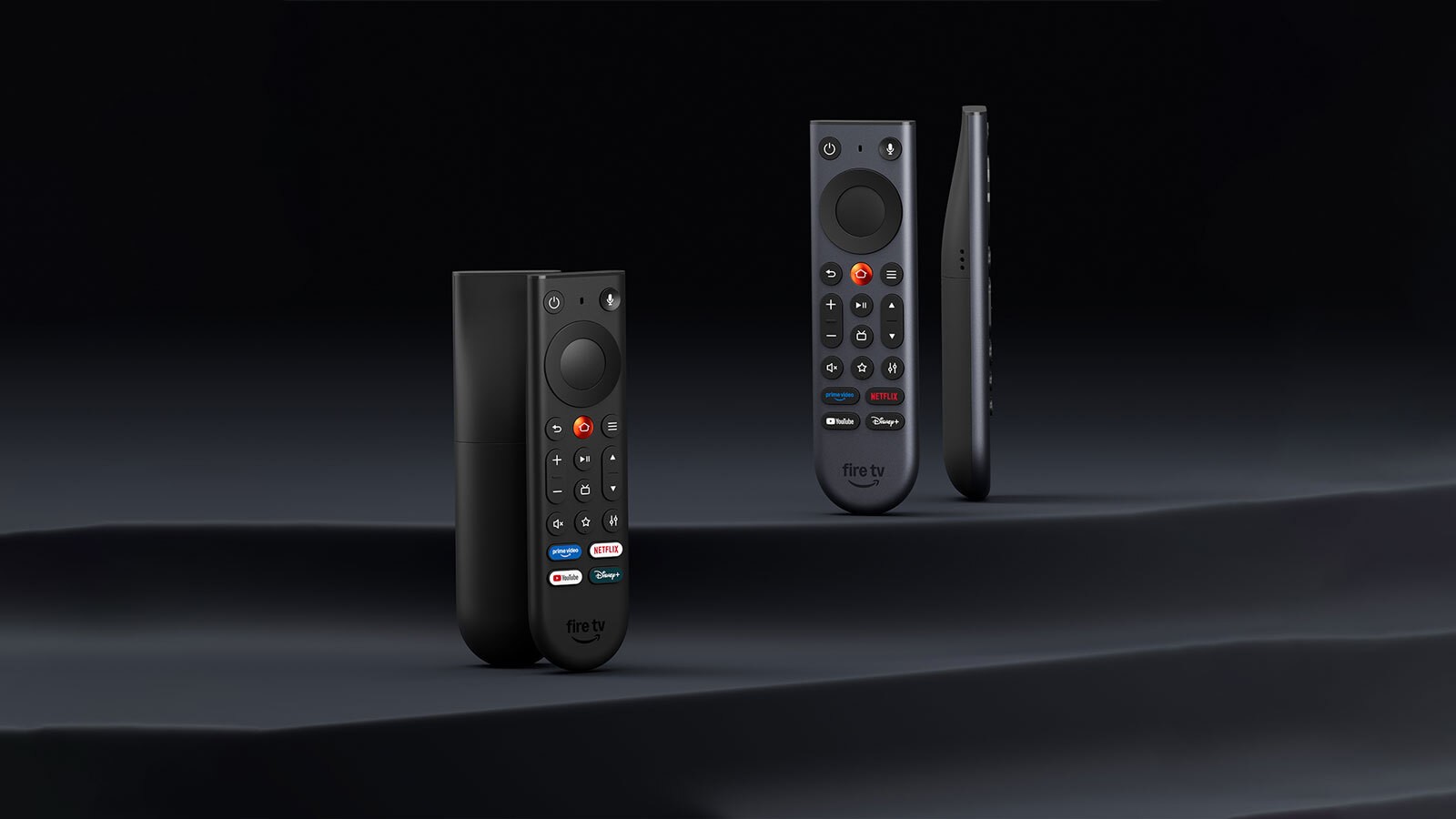Fire TV Remote and the aluminum Fire TV Remote Plus standing on a dark surface