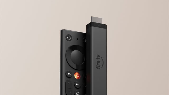 fire-tv-stick-4k-and-new-remote Fire TV Stick 4K standing next to the new Fire TV Remote against a beige background