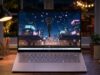 HP OmniBook 5 OLED laptop on a desk at night showing an animated city scene on its screen