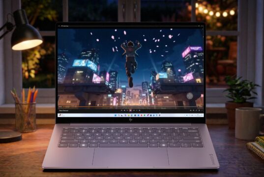 HP OmniBook 5 OLED laptop on a desk at night showing an animated city scene on its screen