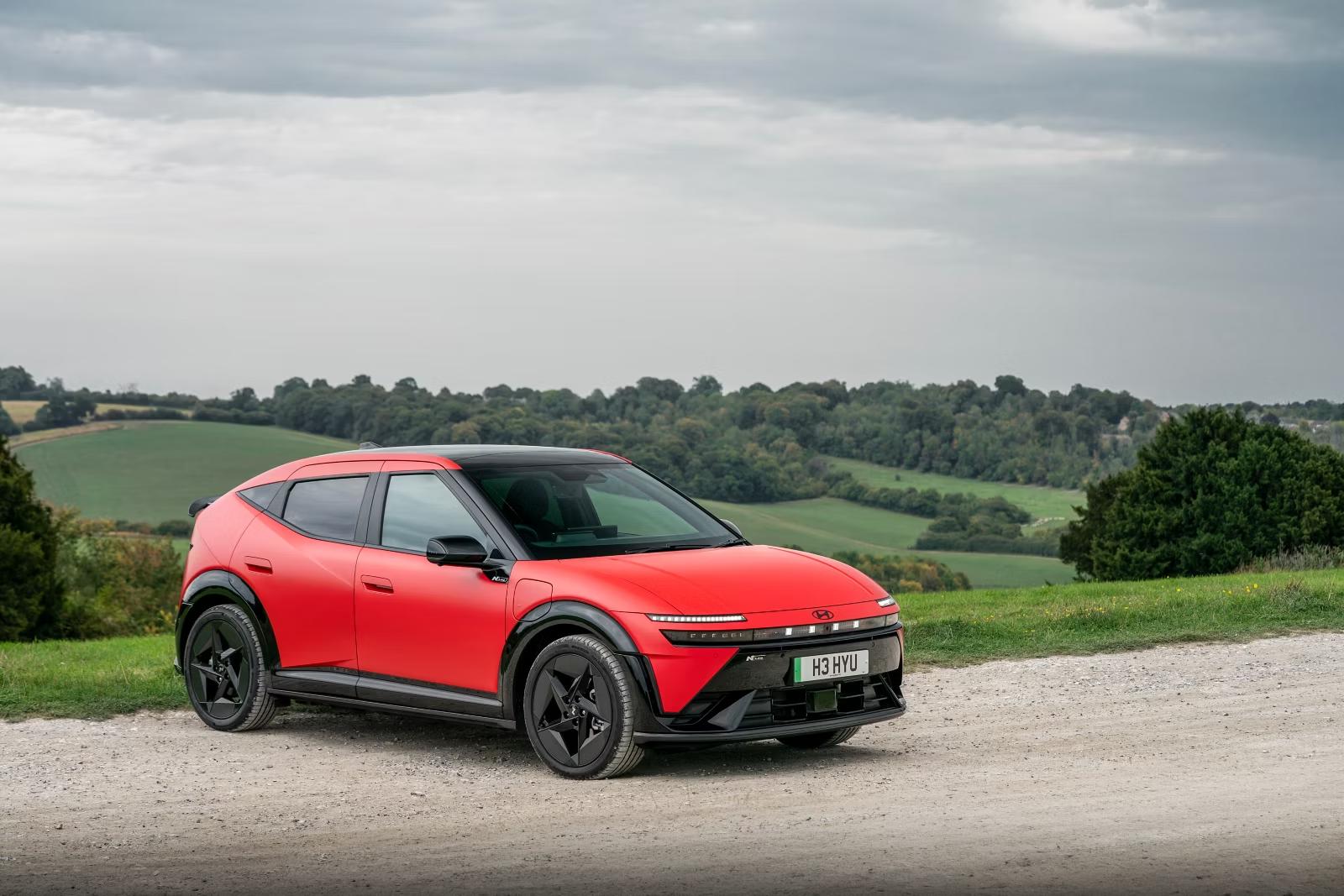 Red Hyundai IONIQ 3 N Line Evo parked on a gravel track with hills behind