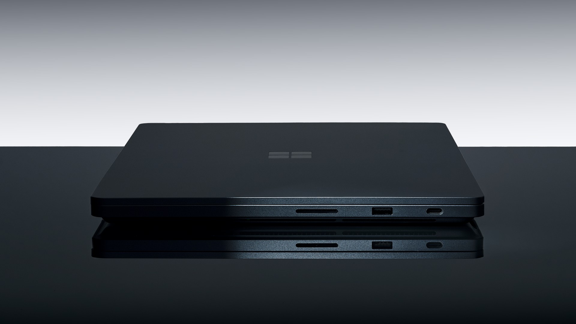 Close-up of the Surface Laptop Ultra edge with the magnetic charging cable attached and a small white indicator light