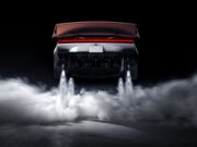 Rear view of the redesigned Tesla Roadster with its active wing deployed, four underbody suction fans, and cold-gas thrusters firing white plumes