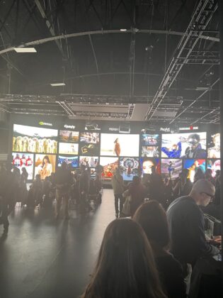 Attendees stand in front of a wall of creative imagery at Pier59 Studios