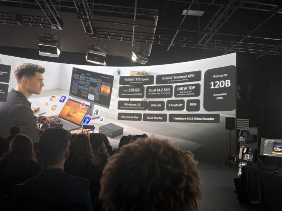 Presenter stands in front of an AI hardware comparison slide
