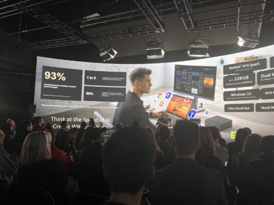 Audience watches a presenter and an AI hardware comparison slide
