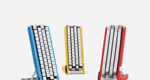 Google Japan’s Gboard Conveyor Belt Keyboard Brings the Keys to You Three conveyor-belt keyboards on stands in blue, yellow and red, each with white keycaps mounted on four vertical belts; the red unit's belts are blurred with the keys in motion