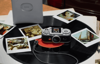 Instax Pal 2 App Bug Shrinks 10 MP USB-C No Frame Saves Instax Pal 2 camera on a vinyl record beside instant prints and a separate printer