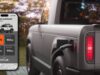 Official Slate charging still: a phone Charge Summary screen showing 100 percent battery, 150 mi total range, 19 min charge time, 115 mi added, and $13.68 cost, beside a gray pickup with a plug in the rear charge port and a lit red tail lamp