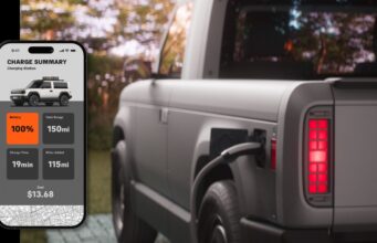 Slate Truck skips infotainment and waits on a later-year app Official Slate charging still: a phone Charge Summary screen showing 100 percent battery, 150 mi total range, 19 min charge time, 115 mi added, and $13.68 cost, beside a gray pickup with a plug in the rear charge port and a lit red tail lamp