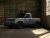 Slate Truck Payload Hits Around 1,550 Pounds With a 5-Foot Bed Blank Slate Truck two-door electric pickup parked inside a sunlit warehouse