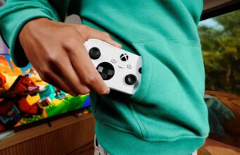 Xbox Nano Controller pre-order opens at $49.99 USD; prices vary A person in a teal hoodie pulls a white Xbox Nano Controller from a front pocket, with a television on in the background